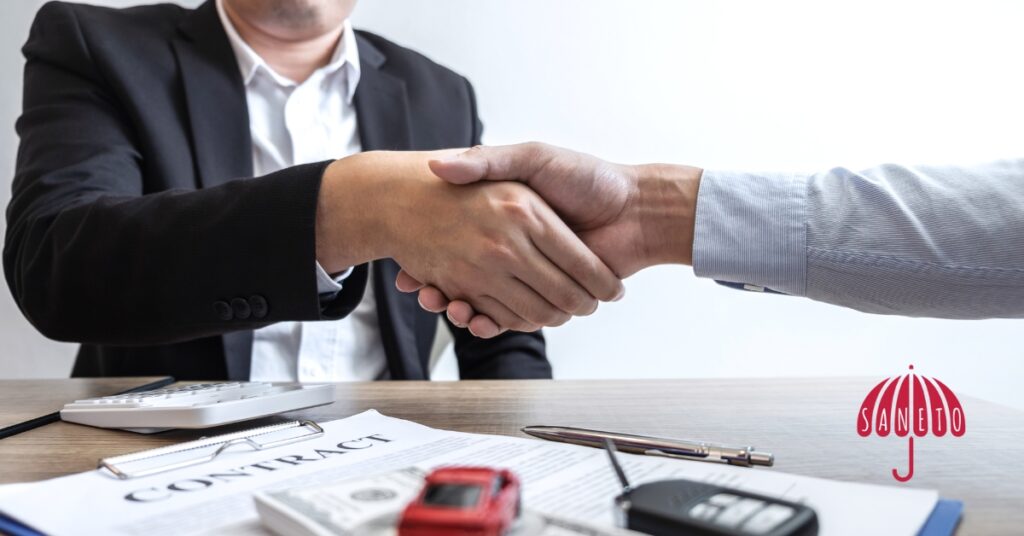 Podání ruky u stolu s dokumenty – symbol konzultace, poradenství nebo spolupráce v oblasti daní a účetnictví